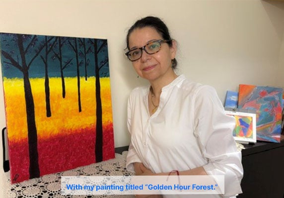Natalie with her painting titled: Golden Hour Forest.